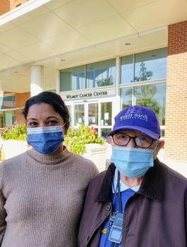 Supriya Mohile and cancer patient Evelyn Bailey standing in front of the Wilmot Cancer Center wearing masks