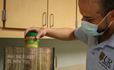 Staff member placing a jar of peanut butter into a bag