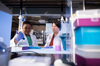 Two female scientists, Nikesha Gilmore and Michelle Janelsins, in a research laboratory