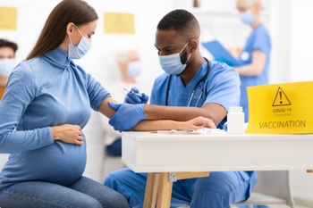 Pregnant woman receiving COVID vaccine at a community clinic.