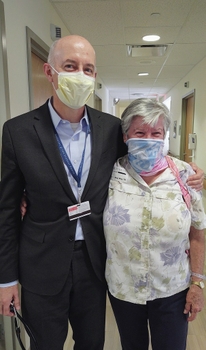 Dr Aram Hezel (masked) stands with his arm around his patient, Dolores House, (masked) at the Wilmot Cancer Institute