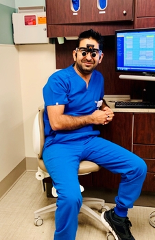 Dr. Kakkar wearing scrubs, seated