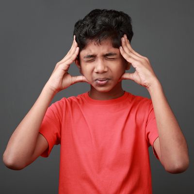 Boy with a painful face expression. Concussion concept.