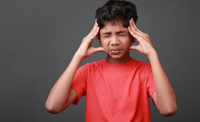 Boy with a painful face expression. Concussion concept.