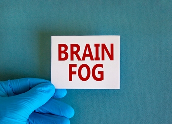 Doctor hand holds White card with words 'brain fog'. Metallic pen. Beautiful white background. Copy space. Medical, covid-19 brain fog concept.
