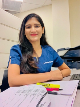 Dr. Thakkar seated wearing scrubs