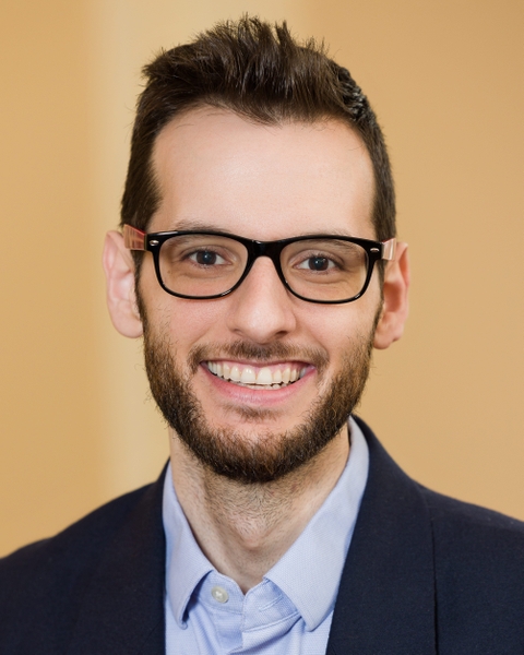 Benjamin Suarez-Jimenez headshot, he is smiling with short neat hair and glasses