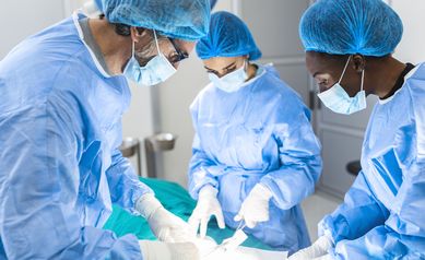 Group of surgeons doing surgery in hospital operating theater. Medical team doing critical operation. Group of surgeons in operating room with surgery equipment. Modern medical background