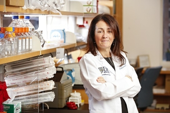 Dr. Ruth O'Regan leans against a laboratory bench