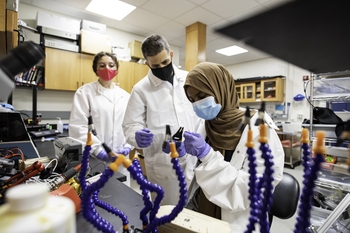 From right: Lulu Abdullahi, a junior at East High School, practices soldering to repair an experiment component with Gomez-Ramirez (center) in The Haptics Lab. Catalina Feistritzer (left), a University of Pittsburgh senior participating in UR’s Summer Research Program, looks on. (University of Rochester photo / J. Adam Fenster)