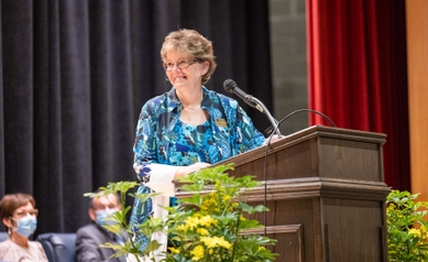 Kathy Rideoutt speaking at a podium
