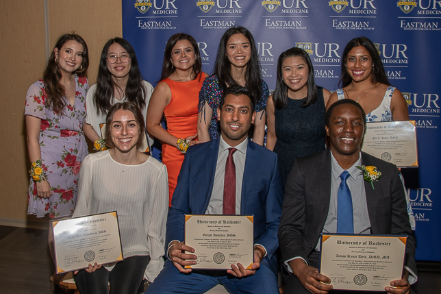 Several EIOH graduates posing with their certificates and degrees