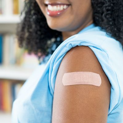 Close up - plaster on arm of latin american woman after third vaccination against Covid 19