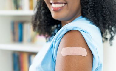 Close up - plaster on arm of latin american woman after third vaccination against Covid 19