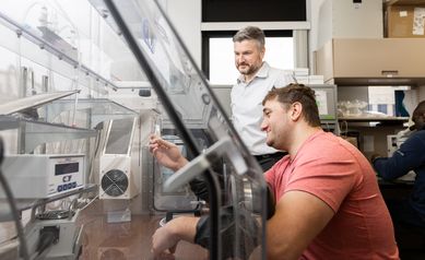 Postdoctoral fellow Andrew Peter Bischer, PhD (front) works in hypoxic chamber with Andrew Wojtovich, PhD.