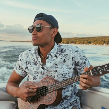 Jesse in sunglasses playing a ukelele.