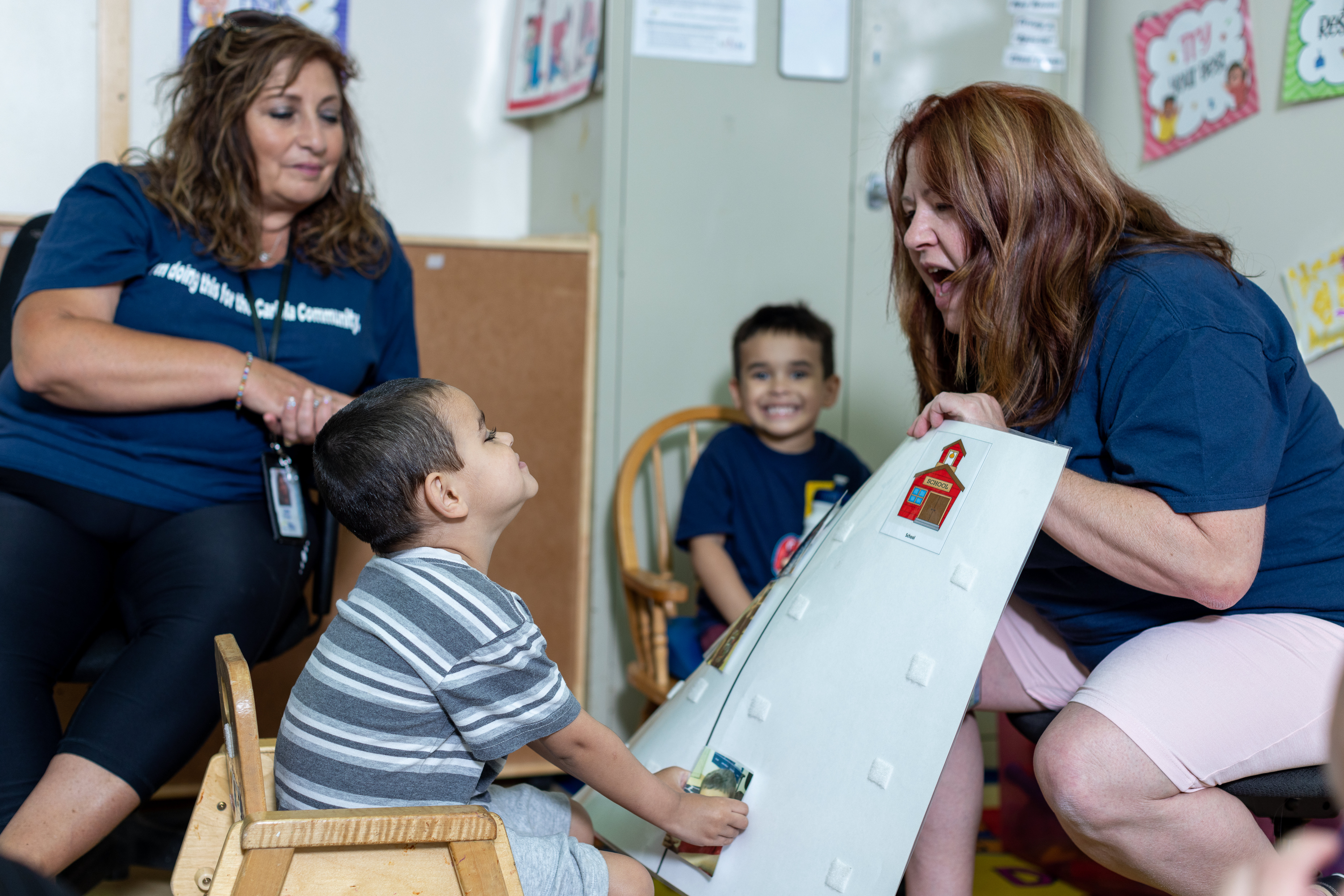 teachers work with two students in classroom.