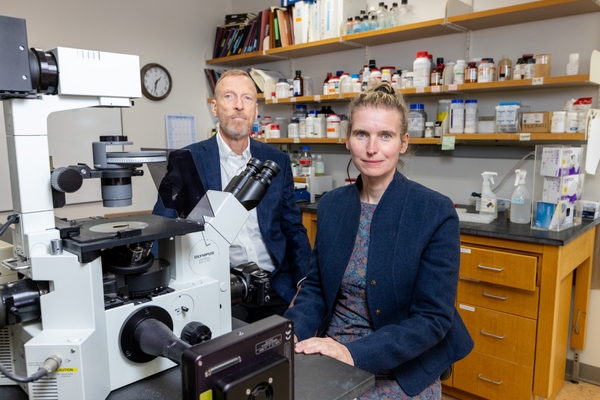 Charles Thornton, MD, and Johanna Hamel, MD, at bench with microscope in a lab at the University of Rochester Medical Center.