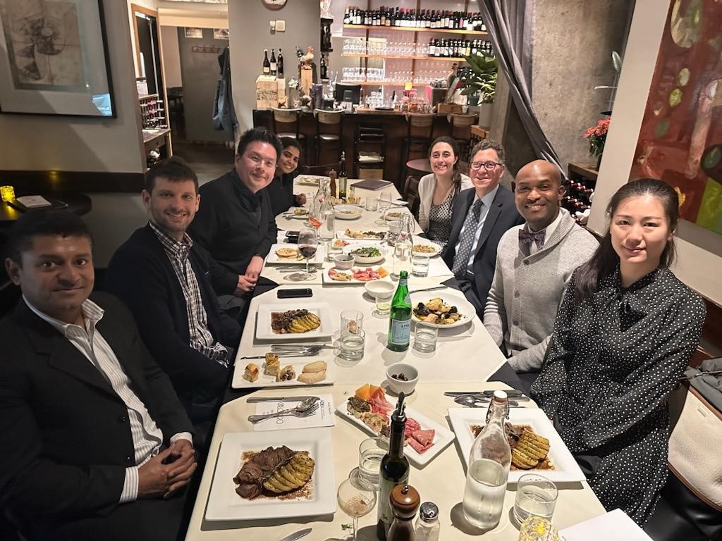 large group at restaurant dinner table looking at camera