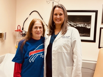 Heart recipient Denise Champagne, wearing a Buffalo Bills shirt with her transplant surgeon Kate Wood, wearing a white coat.