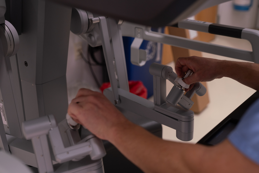 A surgeon uses the hand controls of a surgical robot