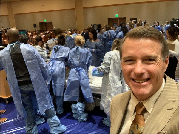 Mark Foley, MD stands in front of a simulated resuscitative cesarean section