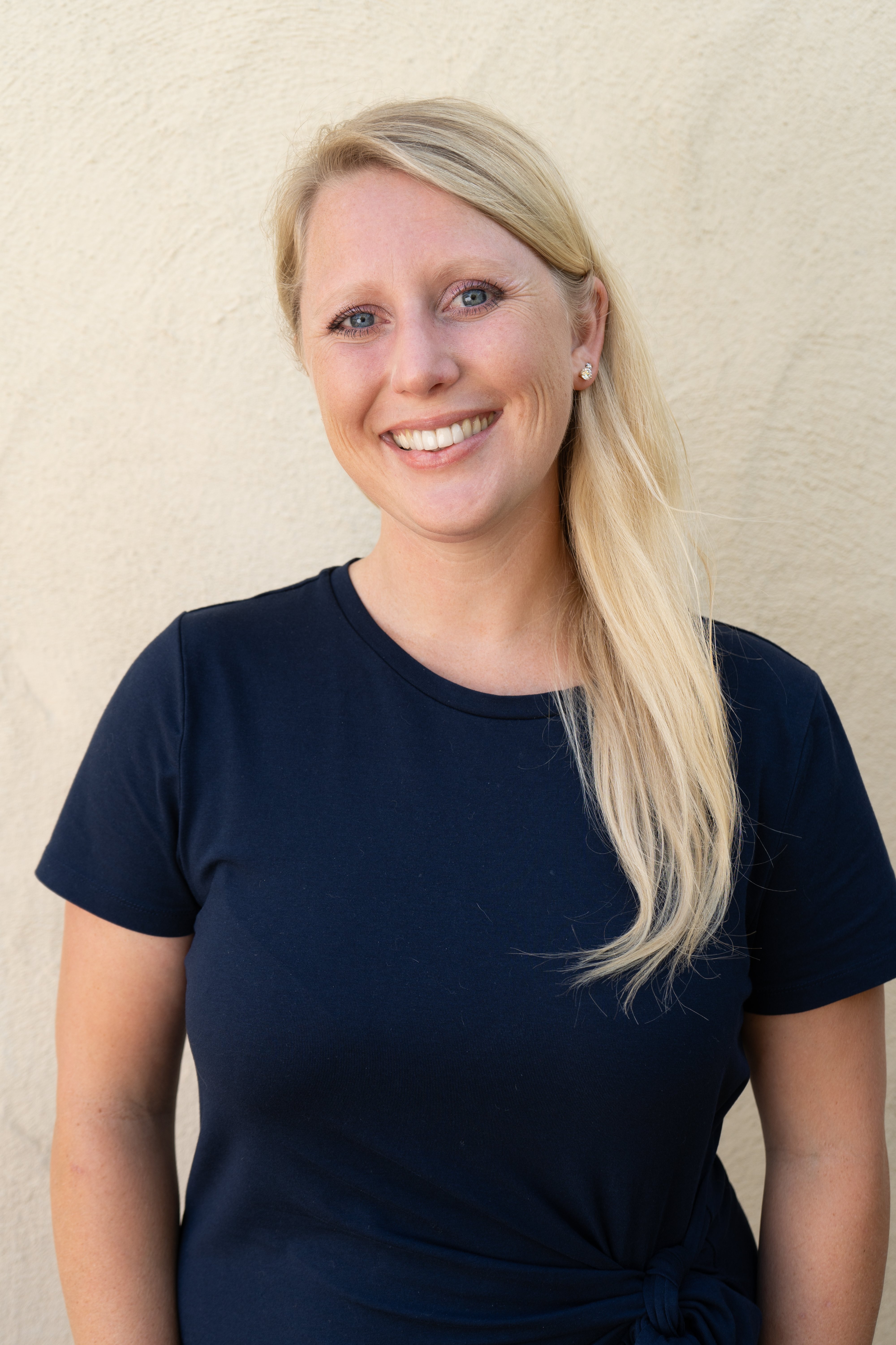 Victoria Popov headshot long blonde hair, smiling while wearing a blue shirt.