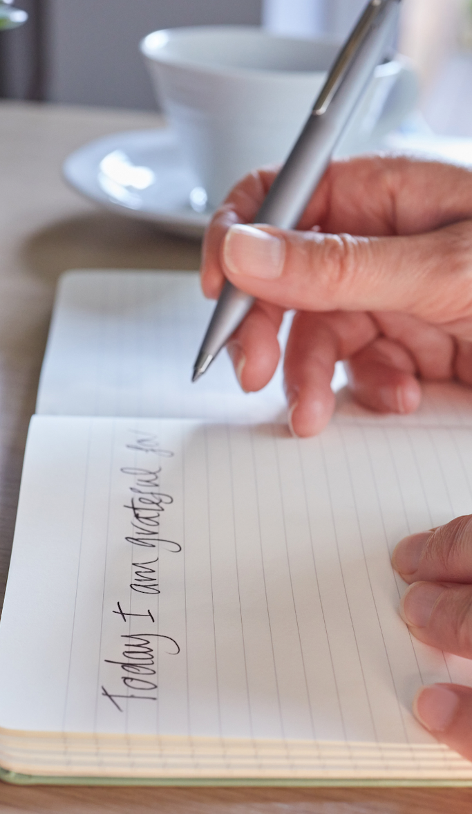 Hand writing in a gratitude journal: "Today I am grateful for..."