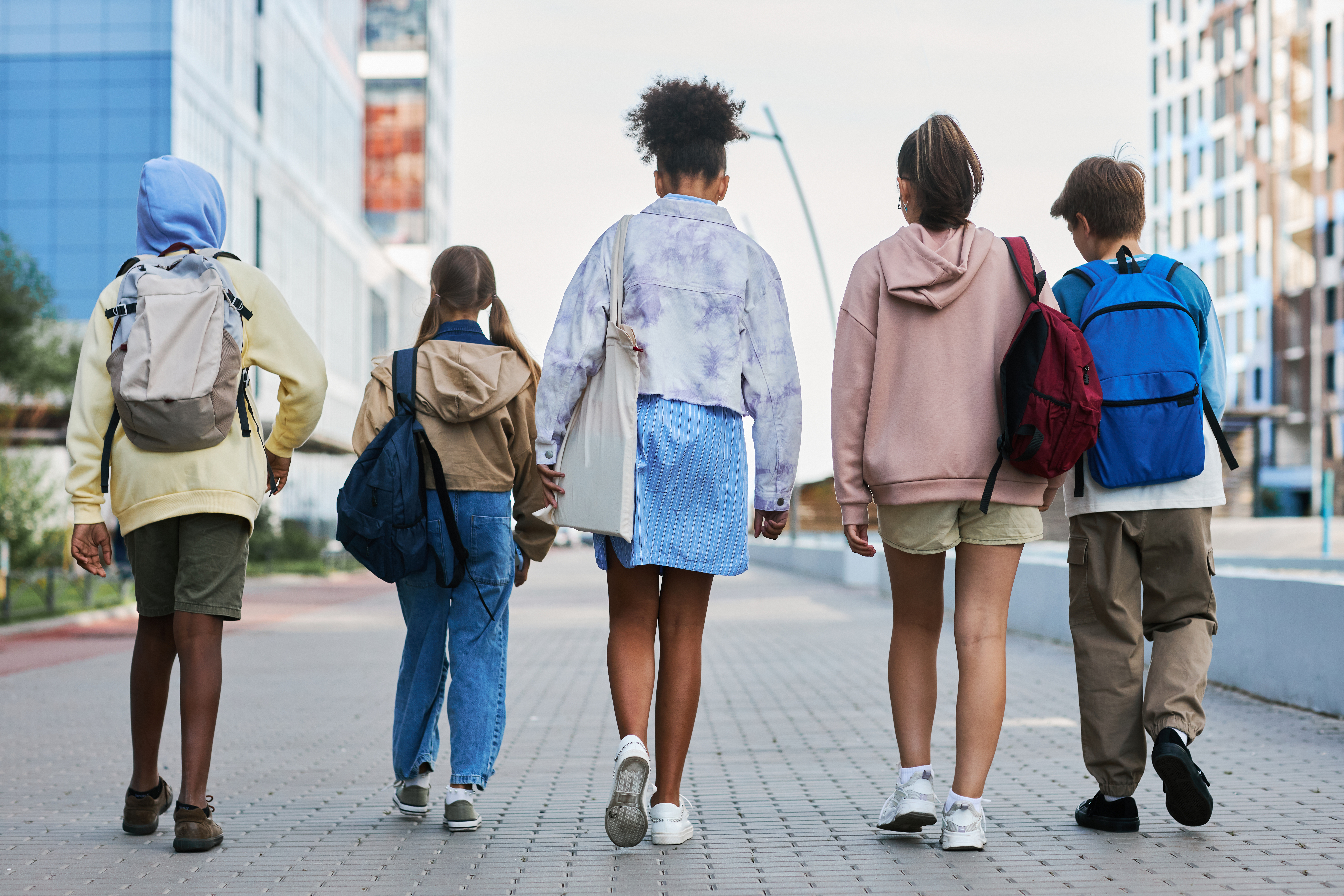 Group of teens walking together wearing backpacks