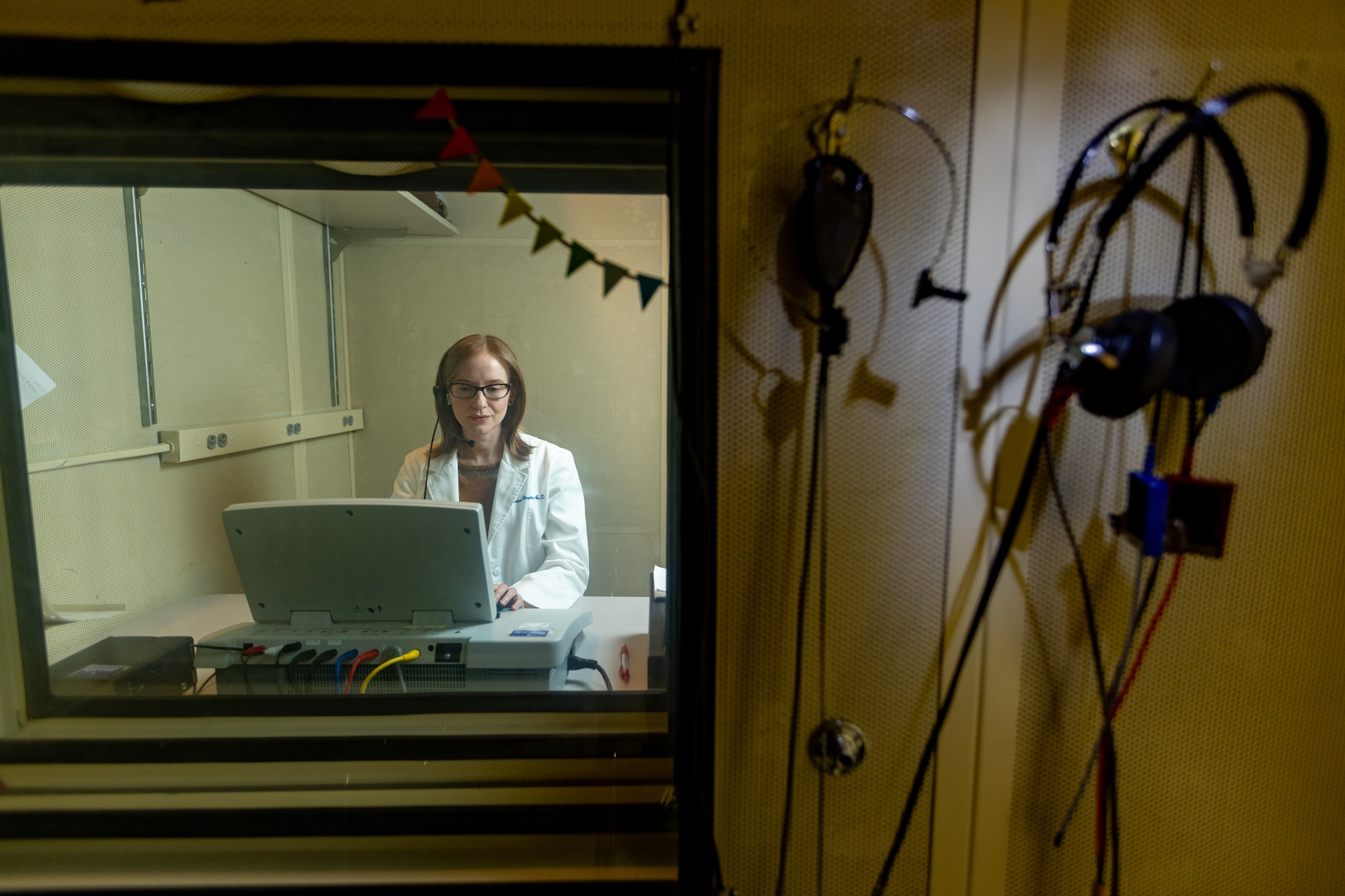 Sarah Hayes, AuD, PhD, works in an audio testing booth in the Medical Center.