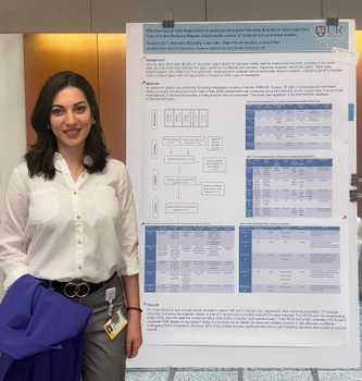 A woman stands next to a scientific poster titled
