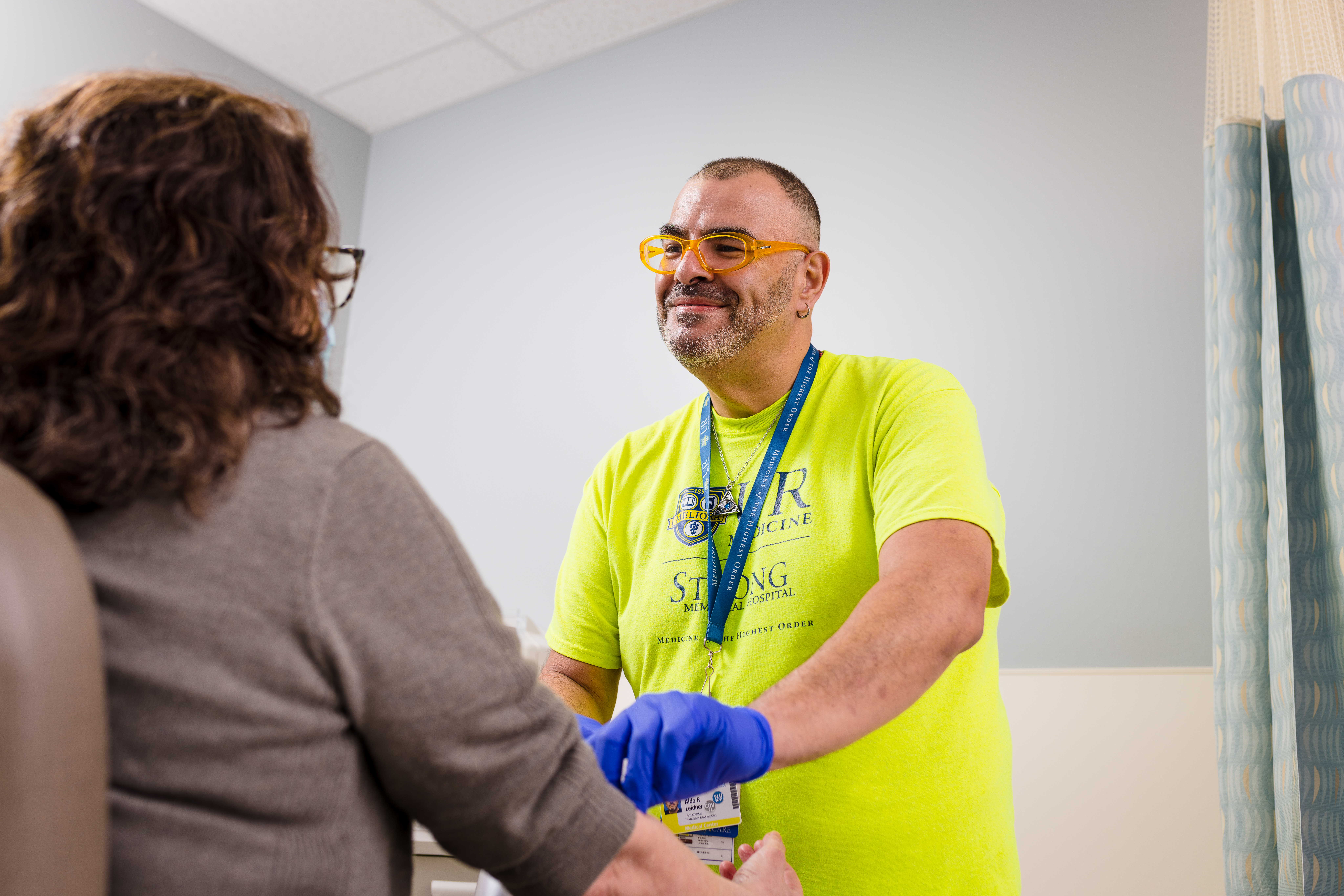 A phlebotomist prepares a patient's arm to draw blood.
