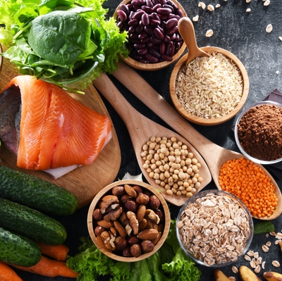 Salmon, avocado, whole grains, and vegetables lie on a kitchen table