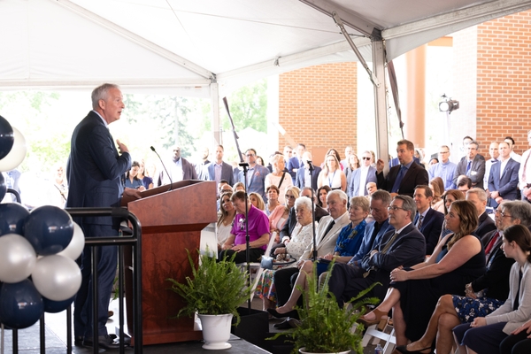 John Foxe at a podium addressing crowd during the event announcing the Golisano IDD Institute