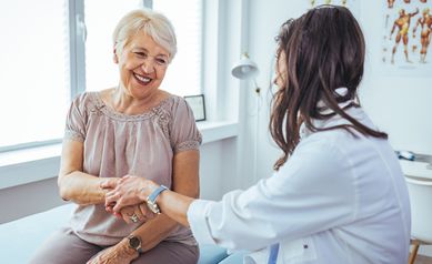Hand of doctor reassuring her female patient.