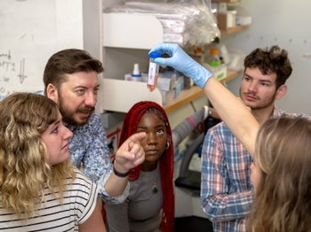 Wilmot researcher Sara Blick-Nitko, PhD, (far right) holds up a tube of cells in front of (right to left) Valodymir Busch, Quinesha Wade, Future Deaf Scientists Co-Director Wyatte Hall, PhD, and Hailey Rogers. Photo credit Erich Camping.