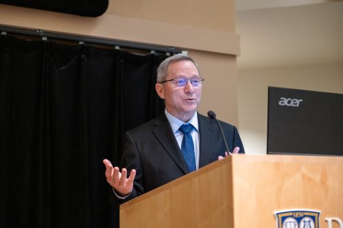 Dr Eliav speaking at podium
