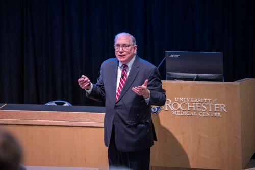 Dr Tabak standing in front of podium addressing audience