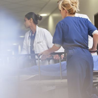 Doctors and nurses wheeling patient in
