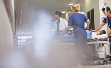 Doctors and nurses wheeling patient in