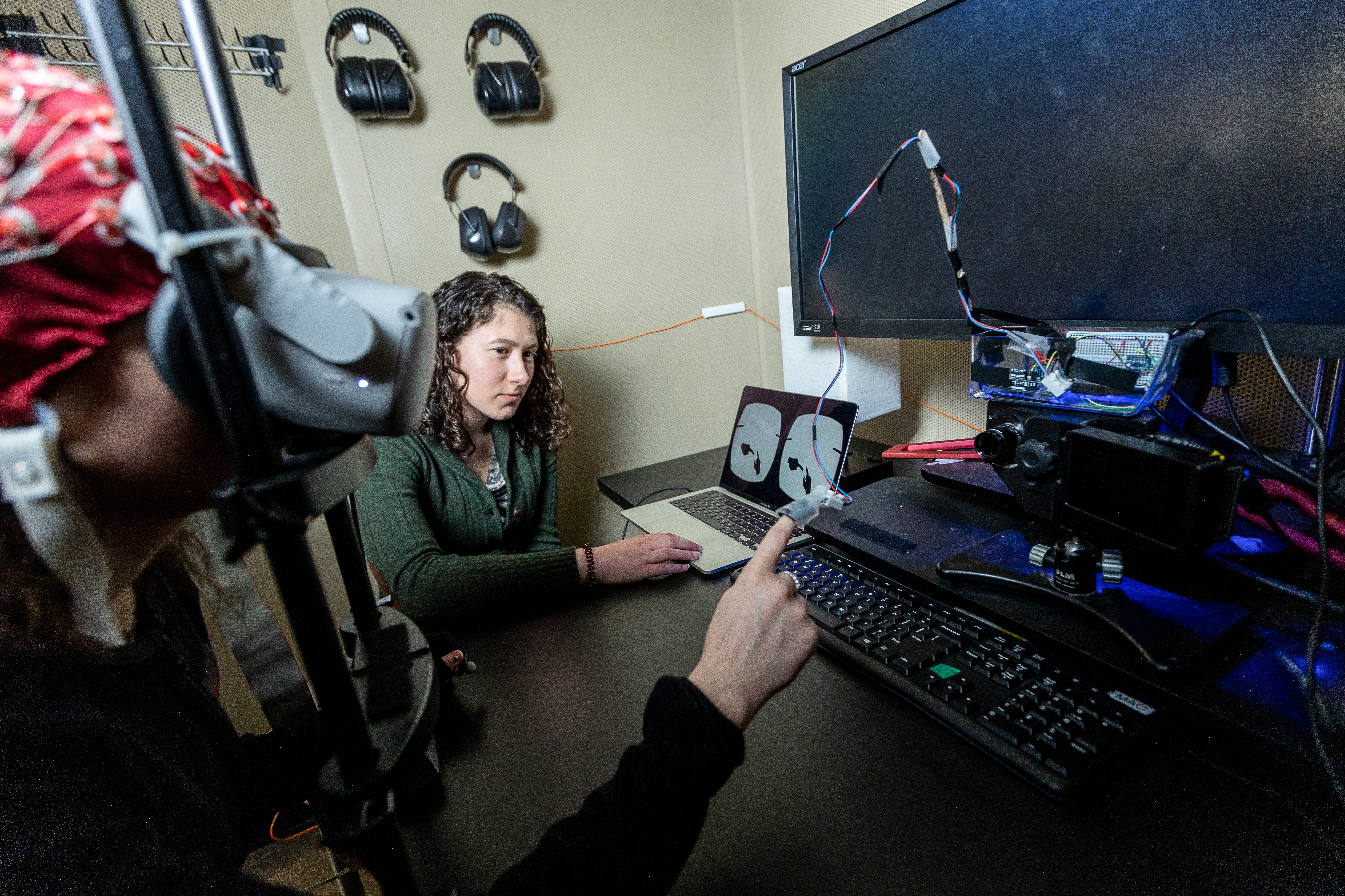 Caption: Isenstein (right) in 2024, with a subject in an EEG booth in the Frederick J. and Marion A. Schindler Cognitive Neurophysiology Lab at the University of Rochester Medical Center. Isenstein uses the advancements she developed to better understand how the brain responds to active and passive touch. 
