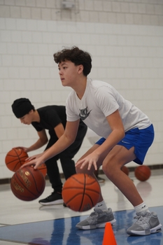 Two individuals dribbling basketballs
