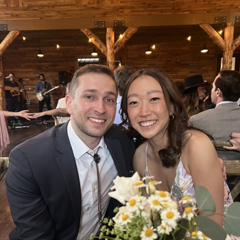 Dr. Barkin and his girlfriend sit at a restaurant table holding flowers.