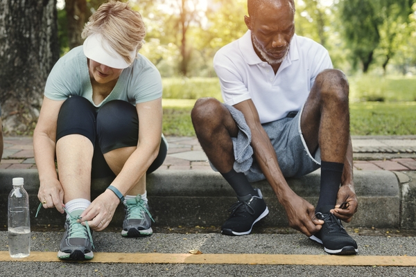 individuals tying sneakers for physical activity