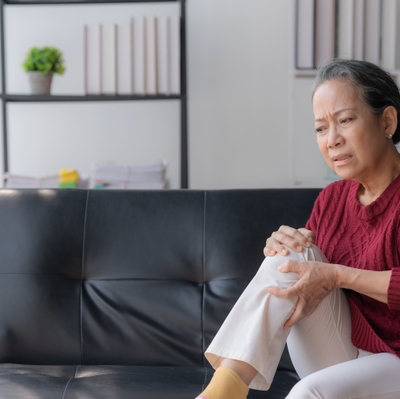 OA woman on couch knee pain