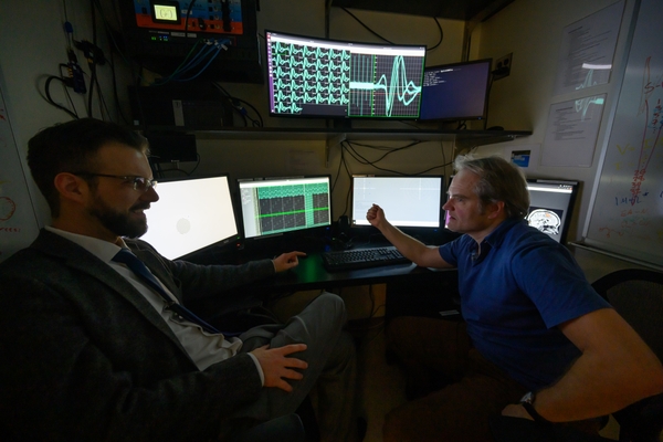 Snyder (left) and Hefner sit at computers in their research lab at the University of Rochester.