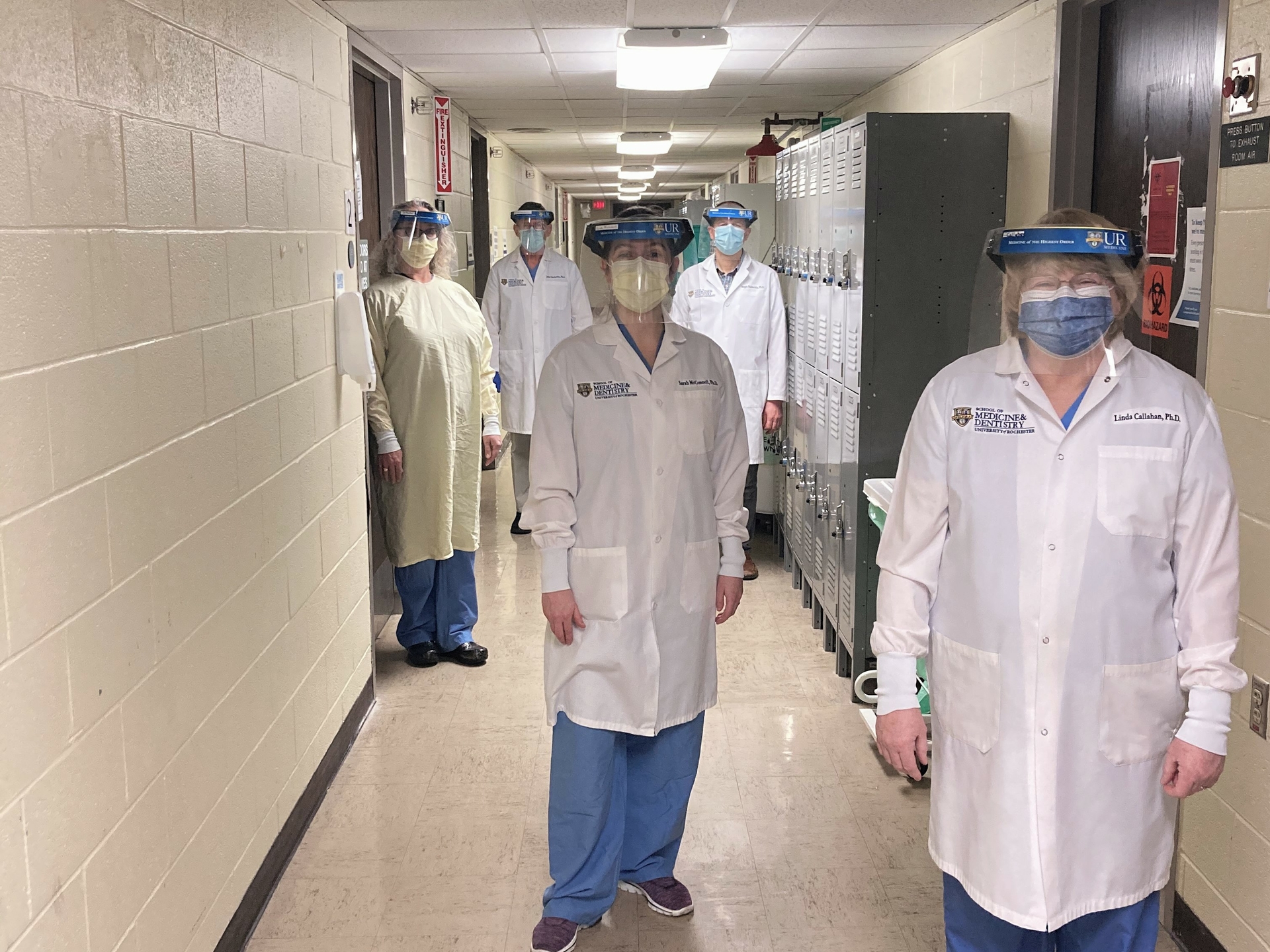 Medical faculty stand socially distance in full PPE