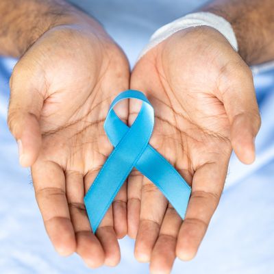 Male hands holding light blue prostate cancer awareness ribbon