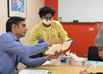Dr. Gajendra and a resident confer during a research visit.