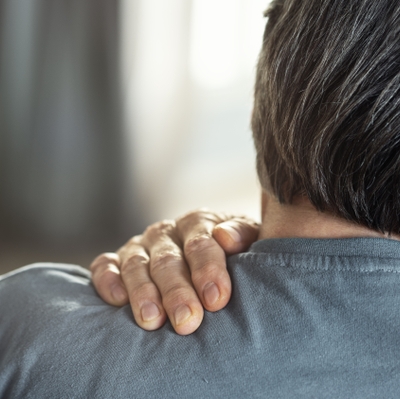 Rear view shot of a man suffering from a shoulder pain